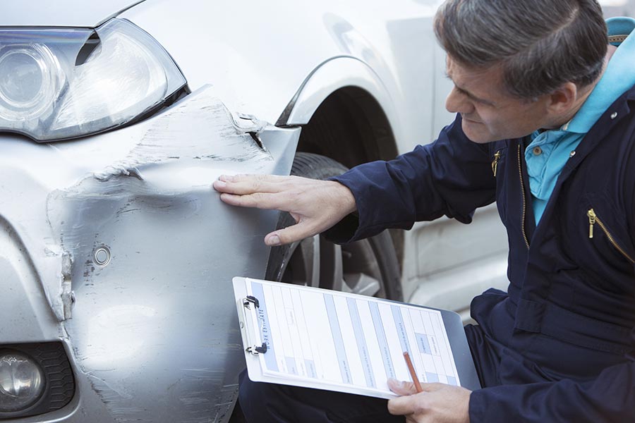 Technician inspecting collision damage